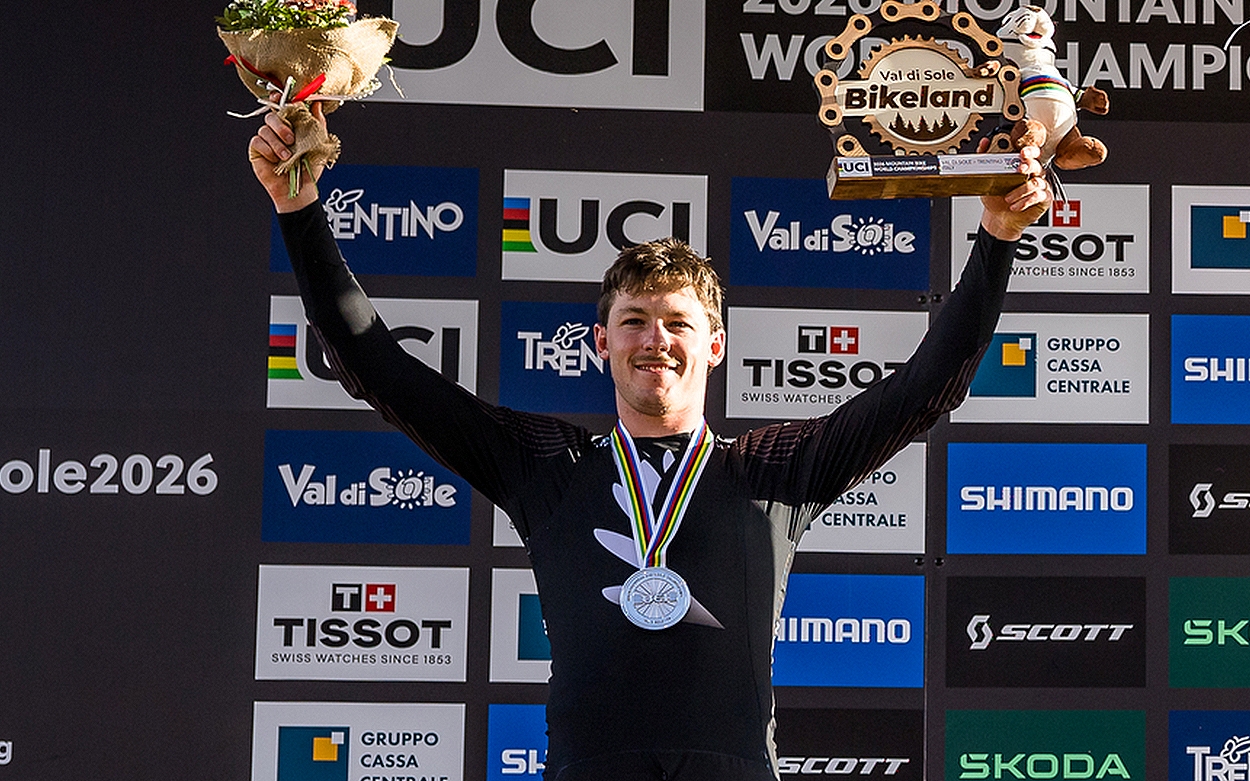 A young man stood on a podium with a silver medal