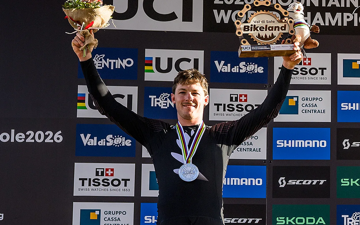 A young man stood on a podium with a silver medal